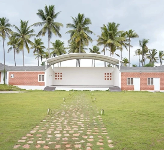 Lawn outer space with AC hall and palm trees at event venue near Sai Baba Colony Coimbatore.